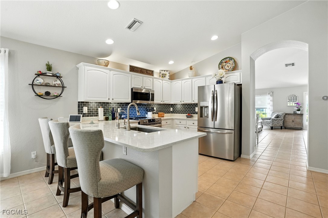 9740 Gladiolus Bulb Loop Fort Myers, FL 33908 - Photo 1 of 26 a kitchen with refrigerator and cabinets