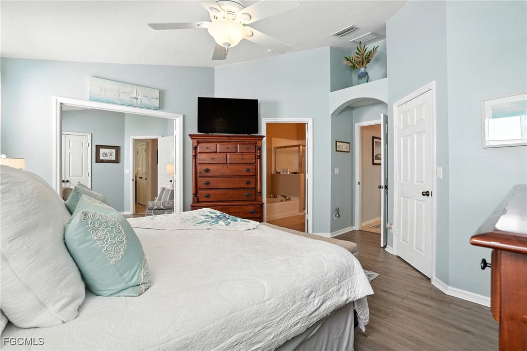 9740 Gladiolus Bulb Loop Fort Myers, FL 33908 - Photo 15 of 26 a spacious bedroom with a bed and a flat screen tv