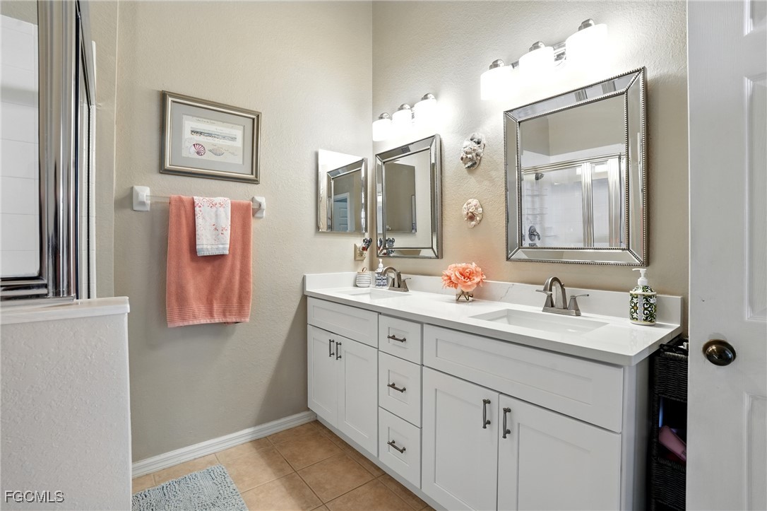 9740 Gladiolus Bulb Loop Fort Myers, FL 33908 - Photo 17 of 26 a bathroom with a double vanity sink and a mirror