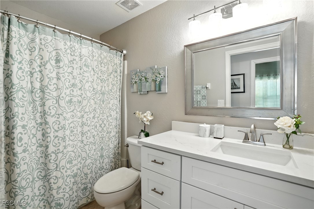 9740 Gladiolus Bulb Loop Fort Myers, FL 33908 - Photo 19 of 26 a bathroom with a sink a toilet and a mirror