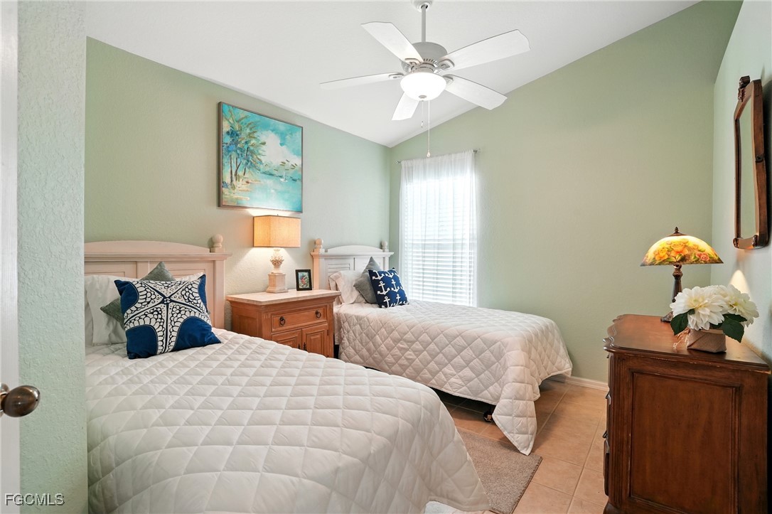 9740 Gladiolus Bulb Loop Fort Myers, FL 33908 - Photo 20 of 26 a bedroom with two beds and a chandelier