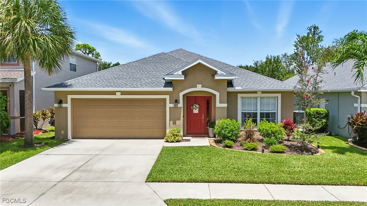 9740 Gladiolus Bulb Loop Fort Myers, FL 33908 - Photo 5 of 26 a front view of a house with a garden and plants