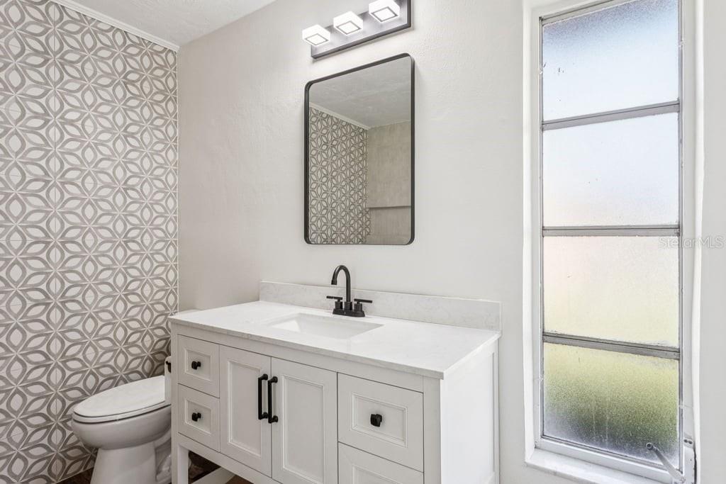 3734 Topsail Trail New Port Richey, FL 34652 - Photo 16 of 65 a bathroom with a sink a toilet and a mirror