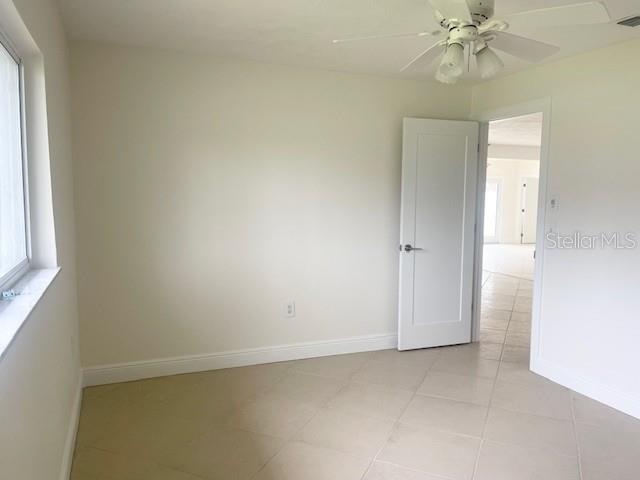 3734 Topsail Trail New Port Richey, FL 34652 - Photo 21 of 65 an empty room with a chandelier fan and windows