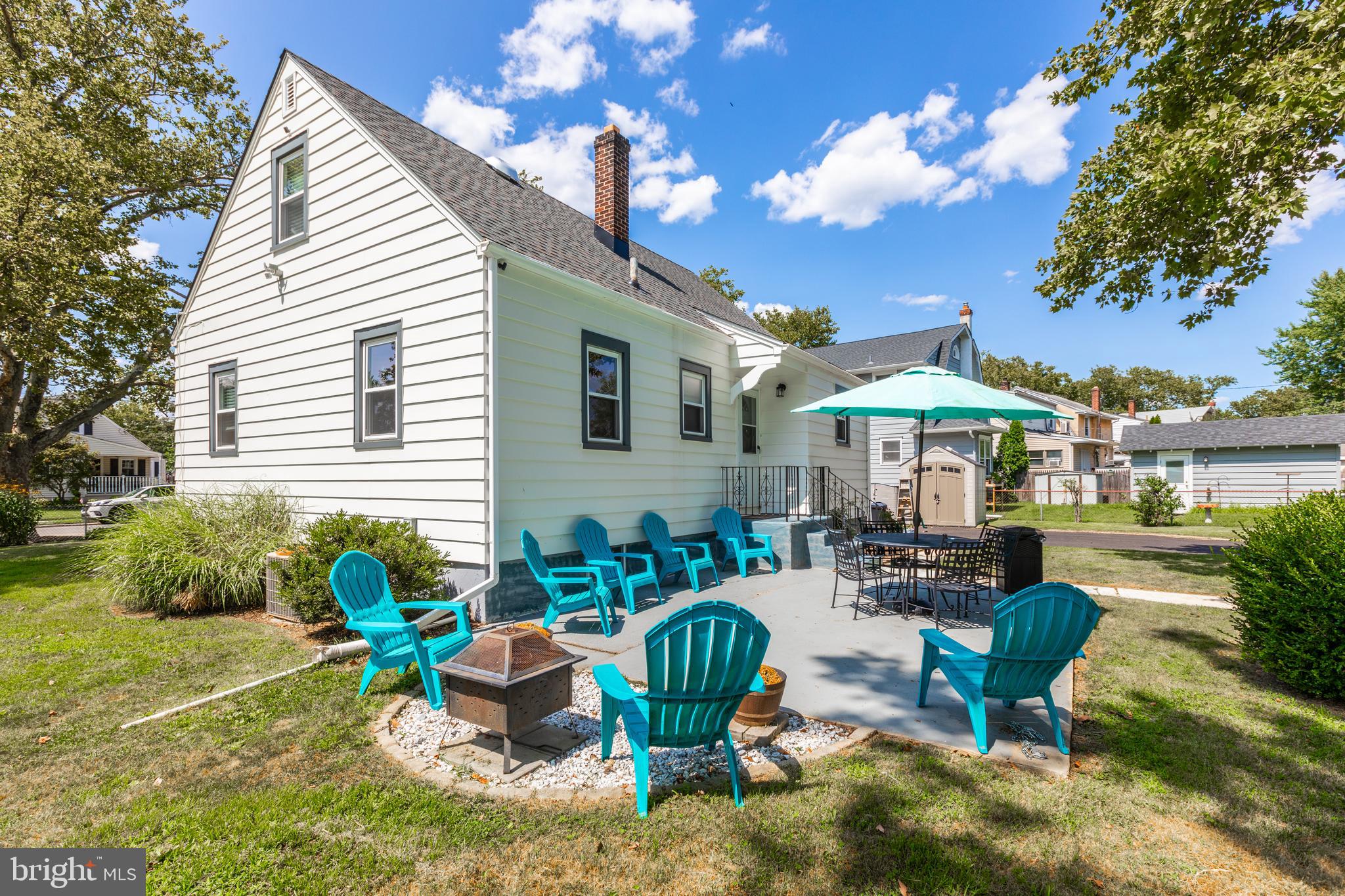 121 Leconey Circle Palmyra, NJ 08065 - Photo 32 of 33 a view of a patio with couches table and chairs under an umbrella