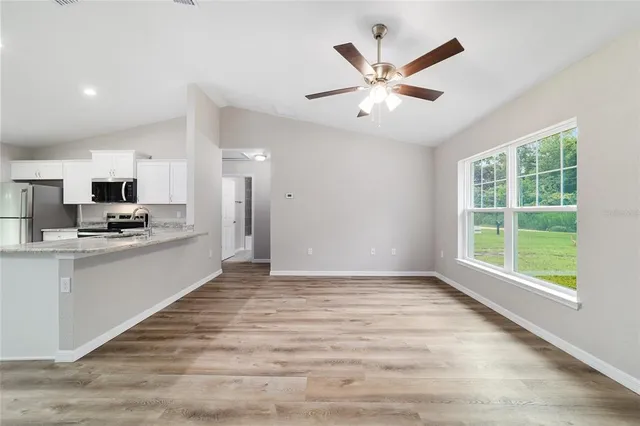 a view of kitchen with cabinets and window
