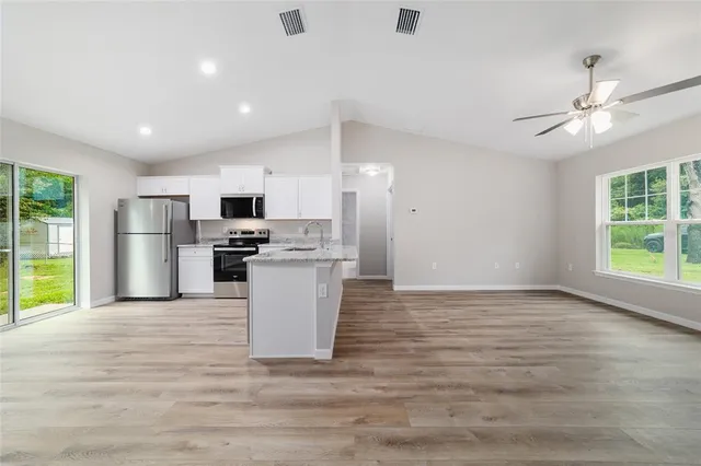 a view of kitchen with refrigerator stove microwave and cabinets