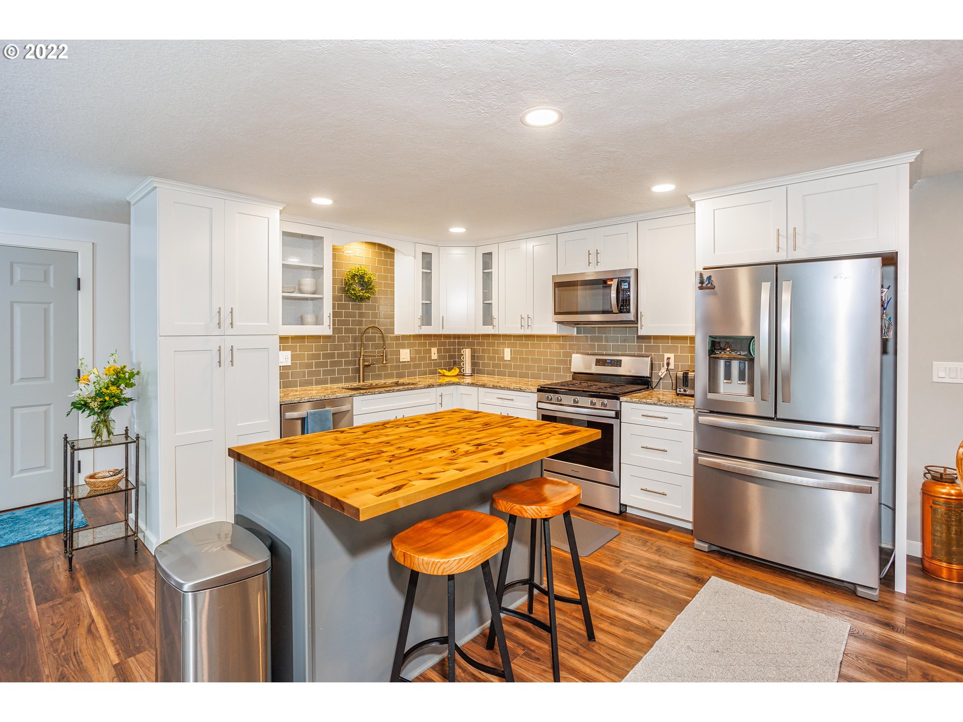 711 North Main Avenue Ridgefield, WA 98642 - Photo 7 of 14 a kitchen with stainless steel appliances granite countertop a refrigerator a sink a stove a dining table and chairs
