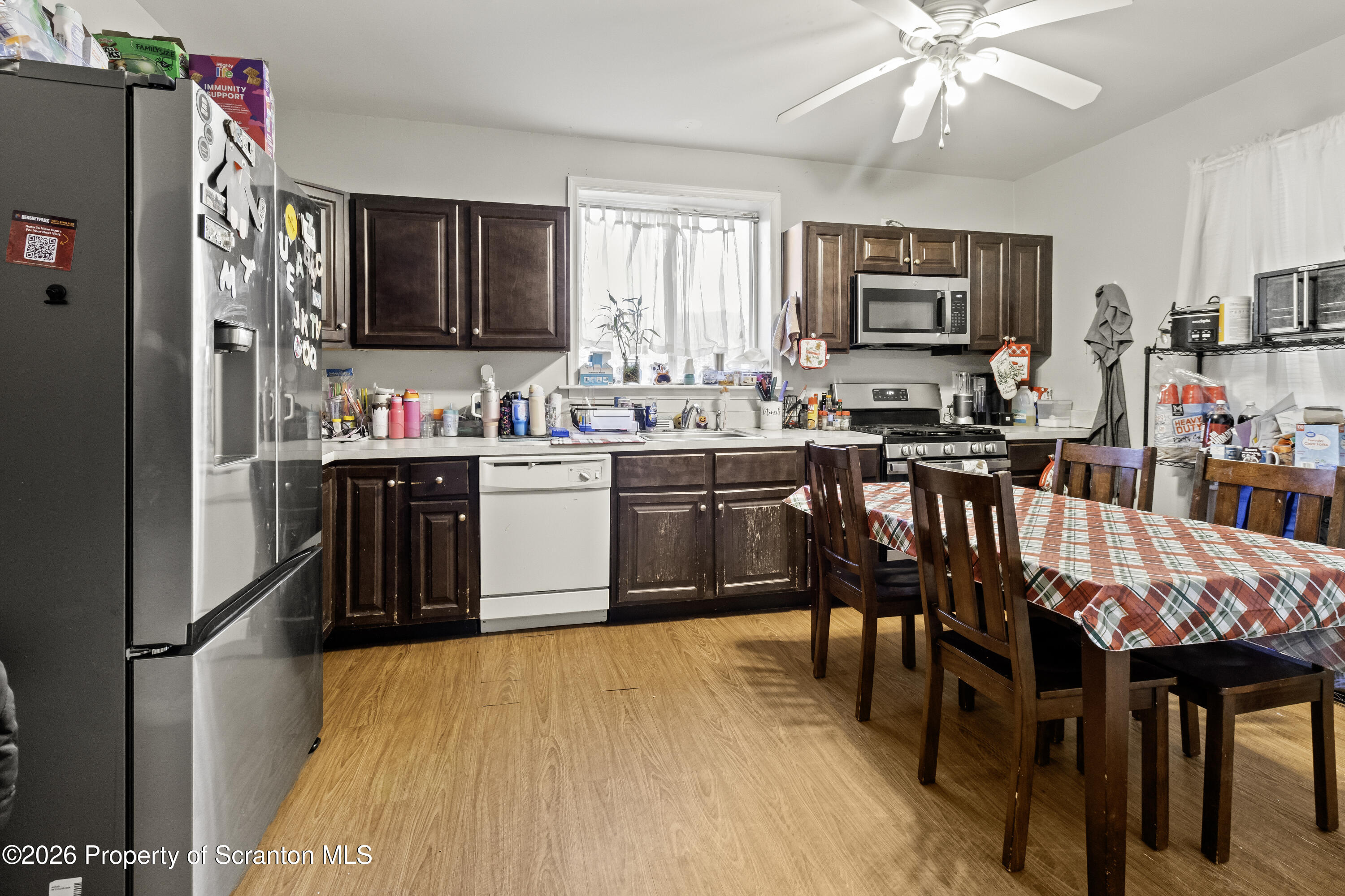 208 Sanderson Avenue Olyphant, PA 18447 - Photo 18 of 31 a kitchen with stainless steel appliances a table chairs refrigerator and cabinets