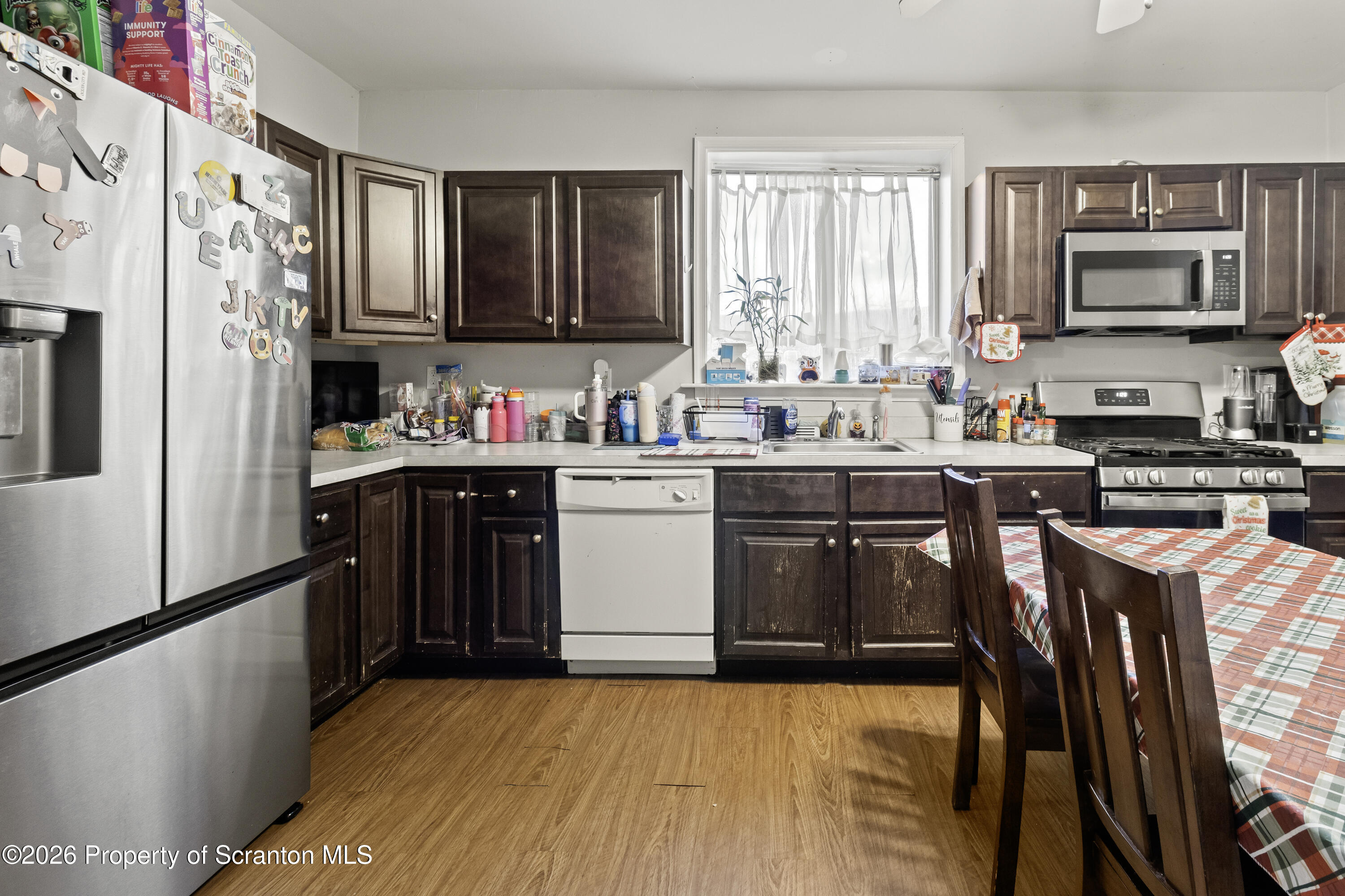 208 Sanderson Avenue Olyphant, PA 18447 - Photo 20 of 31 a kitchen with stainless steel appliances granite countertop a stove top oven a sink dishwasher and a refrigerator with wooden floor