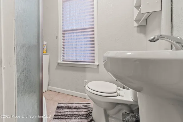 a bedroom with a bed a dresser and a flat screen tv