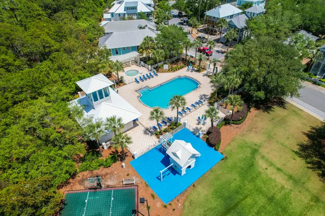 a view of a tennis ground with large trees