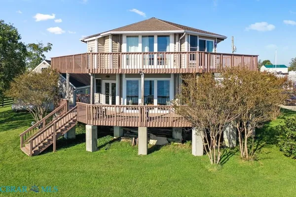 a view of a house with a backyard and deck