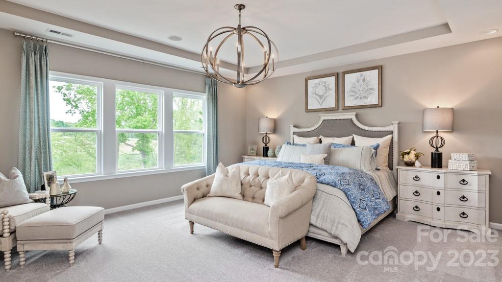 13219 Chopin Ridge Road Huntersville, NC 28078 - Photo 21 of 37 a spacious bedroom with a bed a couch and a window