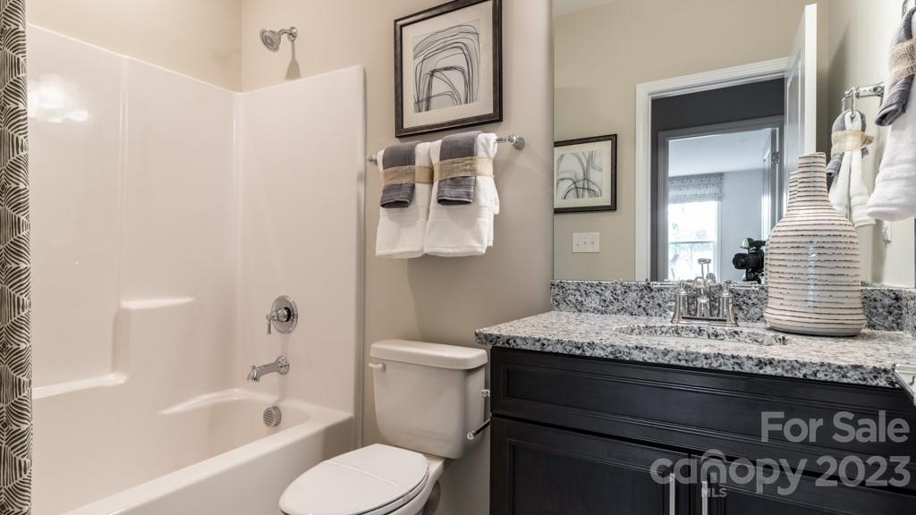 13219 Chopin Ridge Road Huntersville, NC 28078 - Photo 31 of 37 a bathroom with a granite countertop toilet sink and mirror