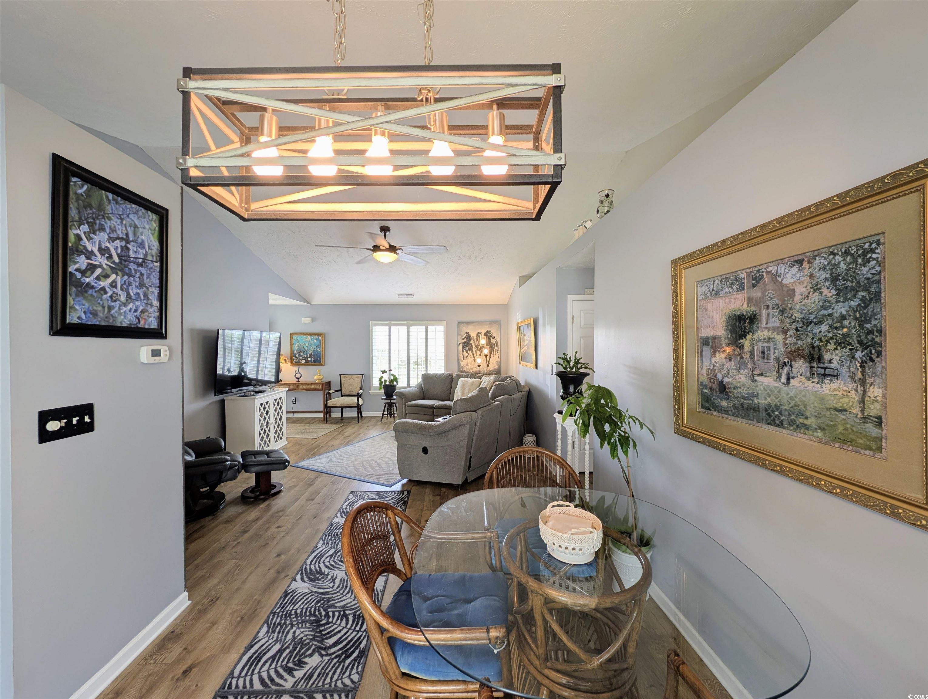 1013 Autumn Drive Murrells Inlet, SC 29576 - Photo 11 of 36 Dining area featuring lofted ceiling, wood finished floors, a chandelier, and ceiling fan