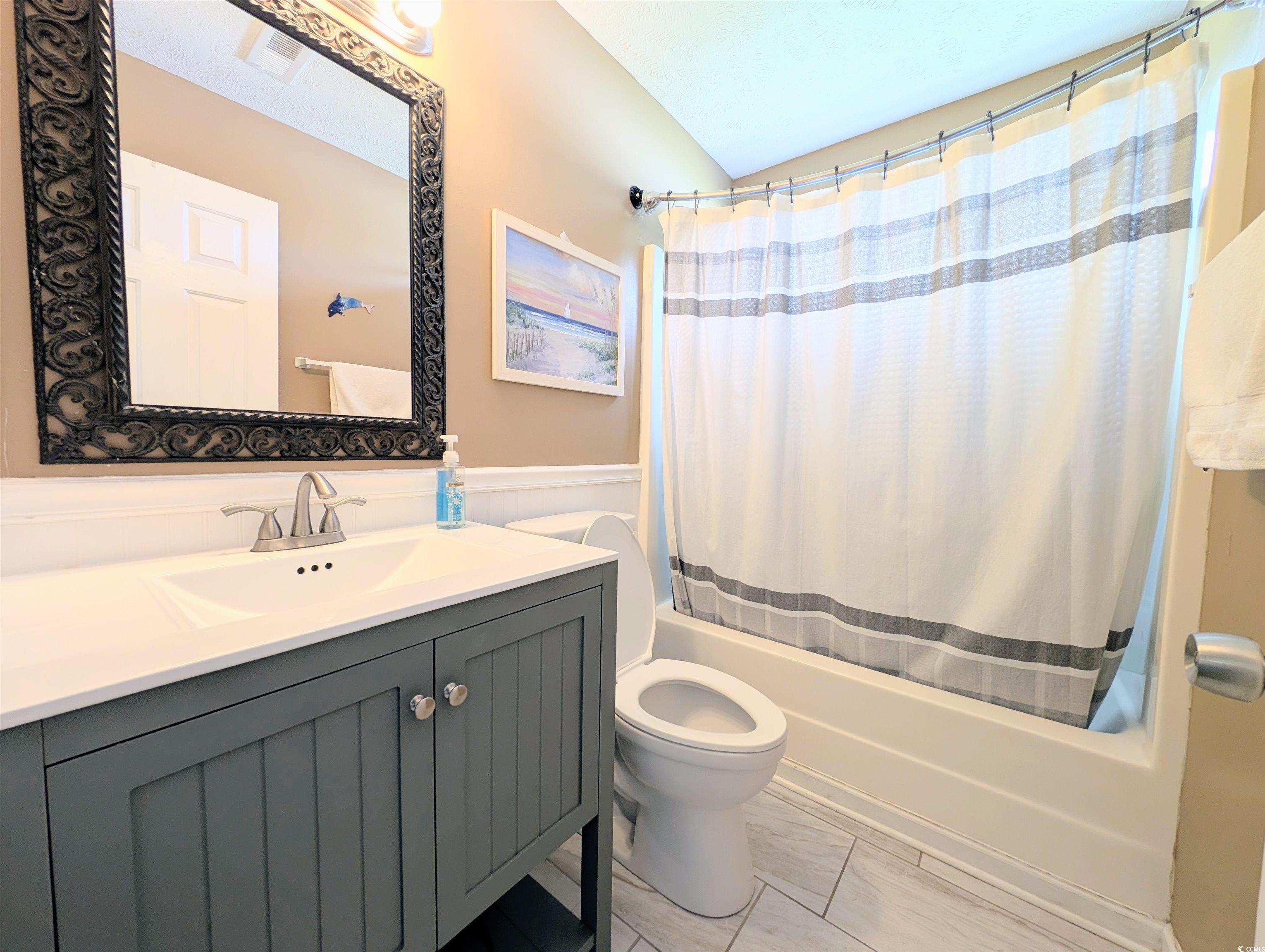 1013 Autumn Drive Murrells Inlet, SC 29576 - Photo 17 of 36 Full bath featuring shower / bath combo with shower curtain, vanity, and wainscoting