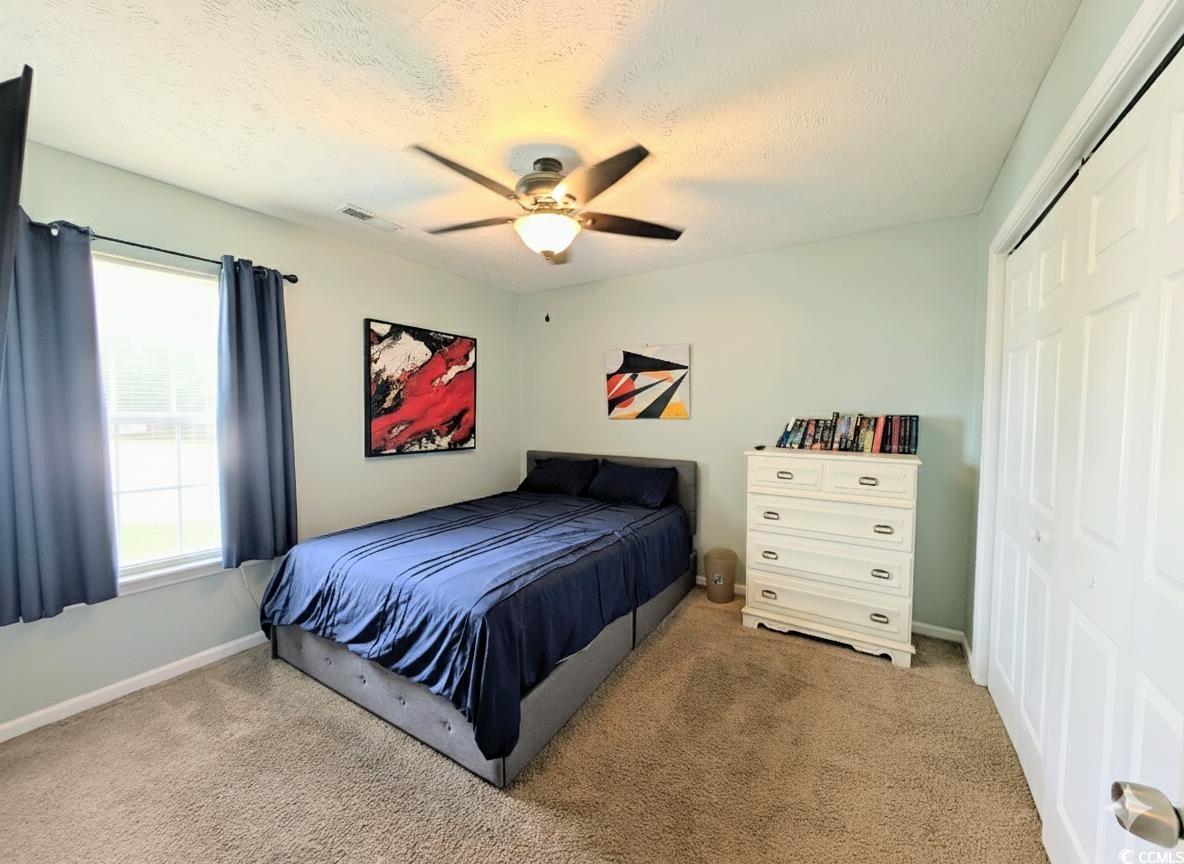 1013 Autumn Drive Murrells Inlet, SC 29576 - Photo 18 of 36 Bedroom with carpet, a closet, a ceiling fan, and a textured ceiling