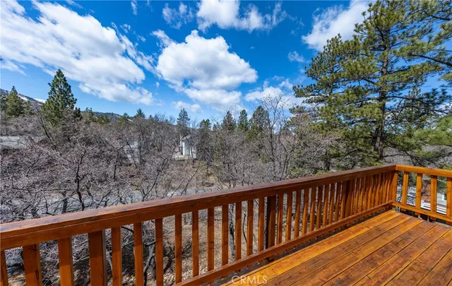 a balcony with wooden floor and trees