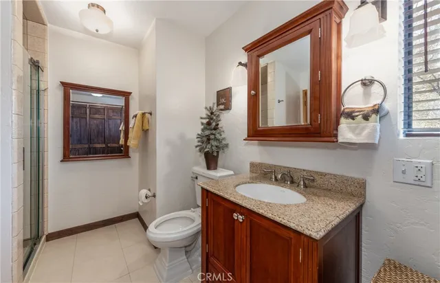a bathroom with a granite countertop toilet sink and mirror