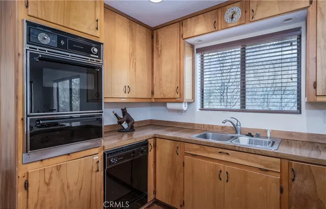 a kitchen with granite countertop a sink cabinets and stainless steel appliances
