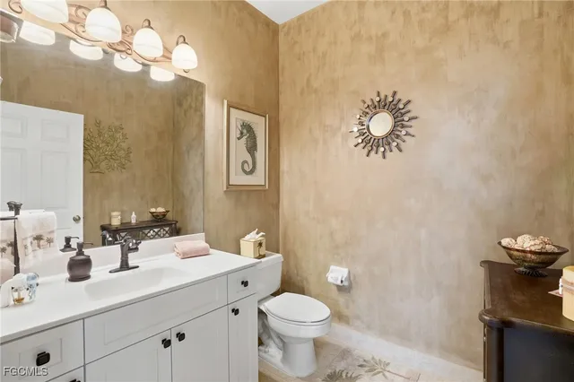a bathroom with a sink mirror and toilet