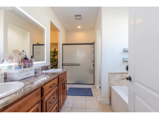 a bathroom with a granite countertop sink a mirror and a bathtub