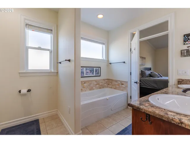 a bathroom with a granite countertop sink mirror bathtub and toilet