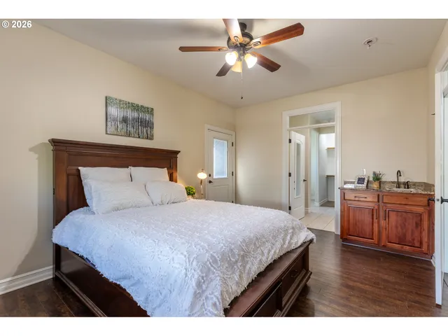 a bedroom with a large bed a chandelier and a dresser