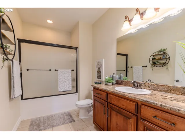 a bathroom with a granite countertop sink mirror vanity and toilet