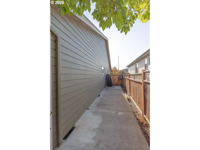 a view of a pathway of a house with wooden fence