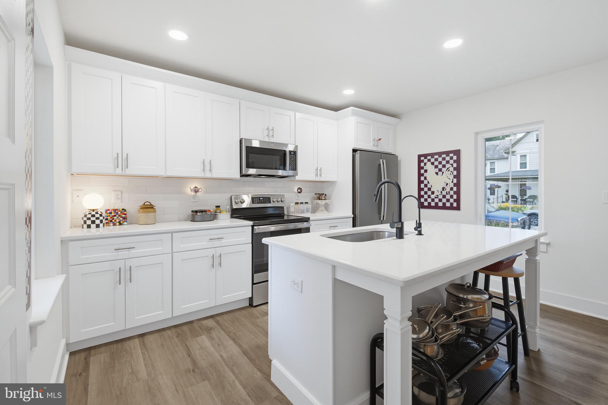 20 Willow Street Lititz, PA 17543 - Photo 3 of 44 a kitchen with stainless steel appliances a stove top oven a refrigerator a sink a dining table and chairs