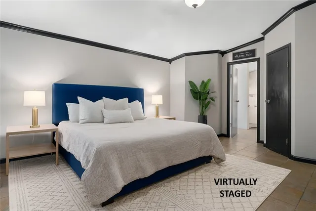 a bedroom with a large bed and a potted plant