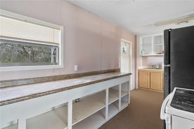 a kitchen with granite countertop white cabinets and white appliances