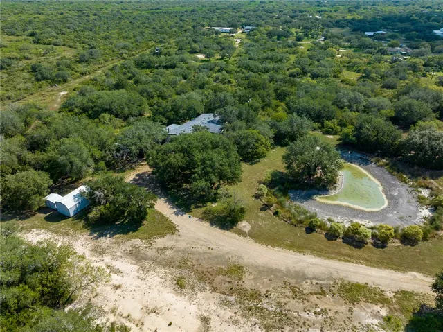 an aerial view of a house with a yard and lake