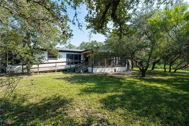 a view of a house with a backyard and a patio