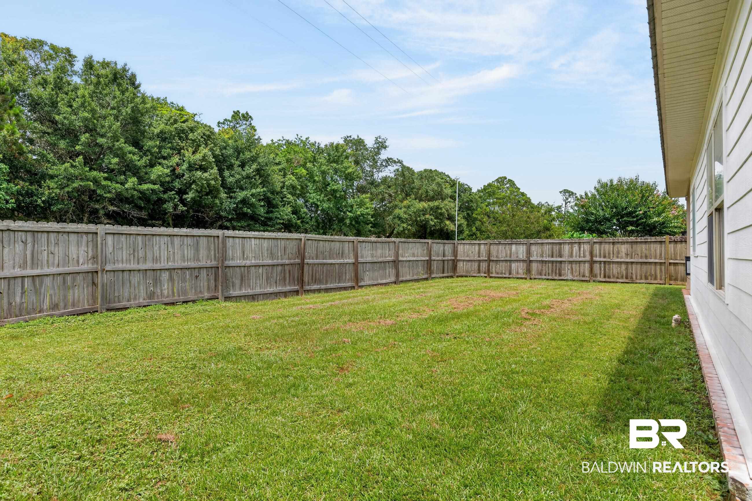 17419 Lewis Smith Drive Foley, AL 36535 - Photo 36 of 38 Expansive backyard featuring a full perimeter wooden privacy fence and a manicured lawn