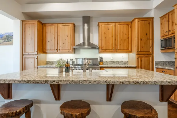 a kitchen with stainless steel appliances granite countertop a sink a stove and a counter space