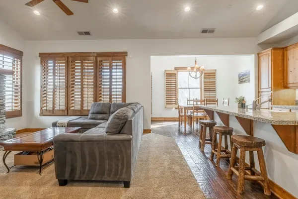 a kitchen with stainless steel appliances granite countertop a table chairs sink and cabinets