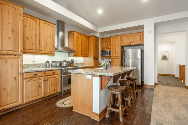 a kitchen with stainless steel appliances granite countertop a stove a sink and a refrigerator