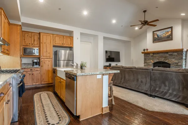 a kitchen with stainless steel appliances granite countertop a stove a sink and a refrigerator