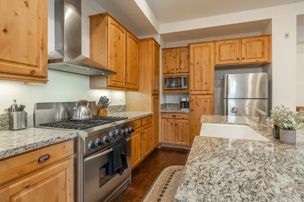 a kitchen with granite countertop center island wooden floor and a fireplace