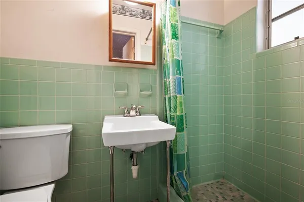 a bathroom with a sink toilet and a mirror