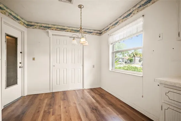 a view of a room with a window and wooden floor