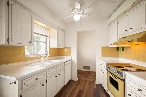a kitchen with a sink stove and cabinets