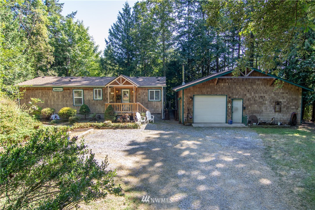 a view of a house with a yard and large trees