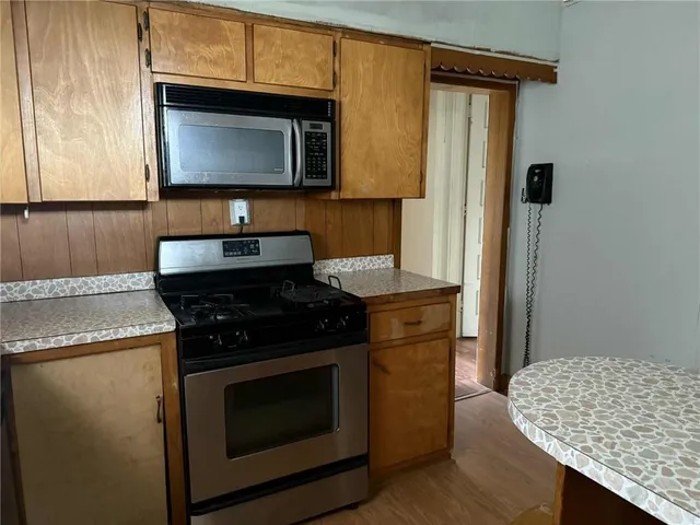 a kitchen with granite countertop cabinets stainless steel appliances and wooden floor