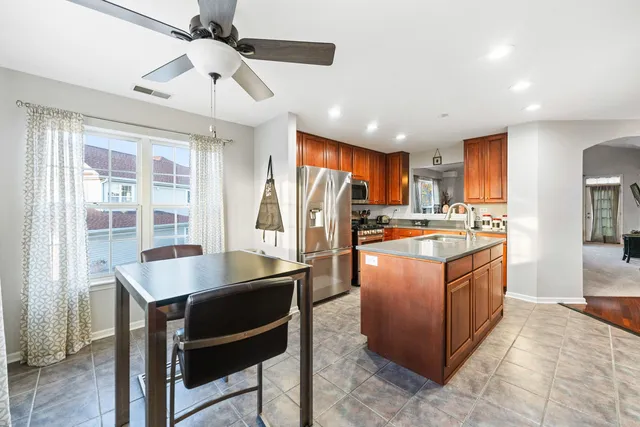 a kitchen with stainless steel appliances granite countertop a refrigerator a sink a stove and island