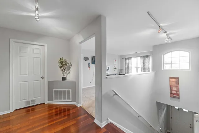 a view of an entryway with wooden floor and a livingroom