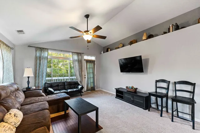 a living room with furniture a flat screen tv and a large window